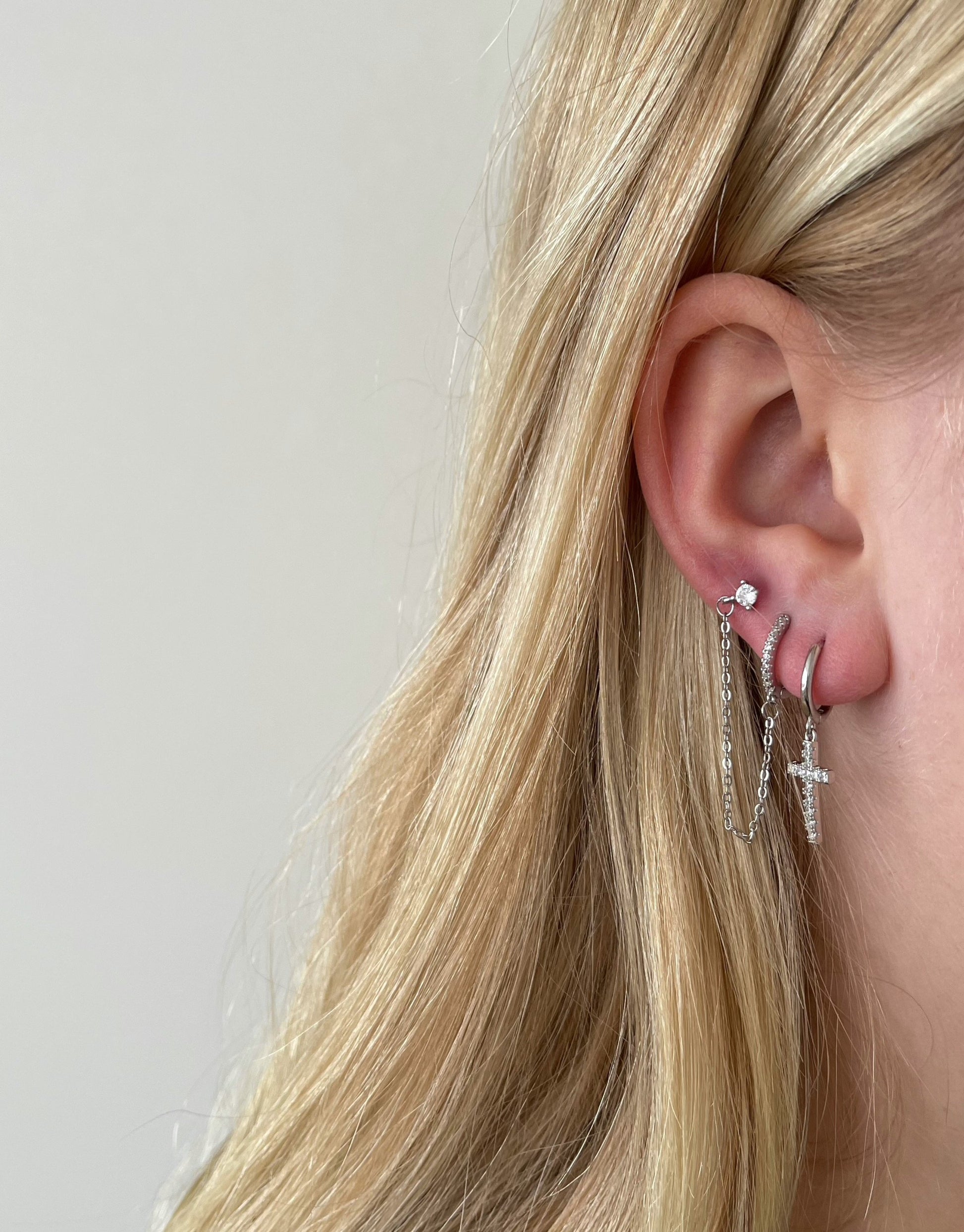 Kors øreringe i sølv.  Elegant kors fyldt med zircon sten.