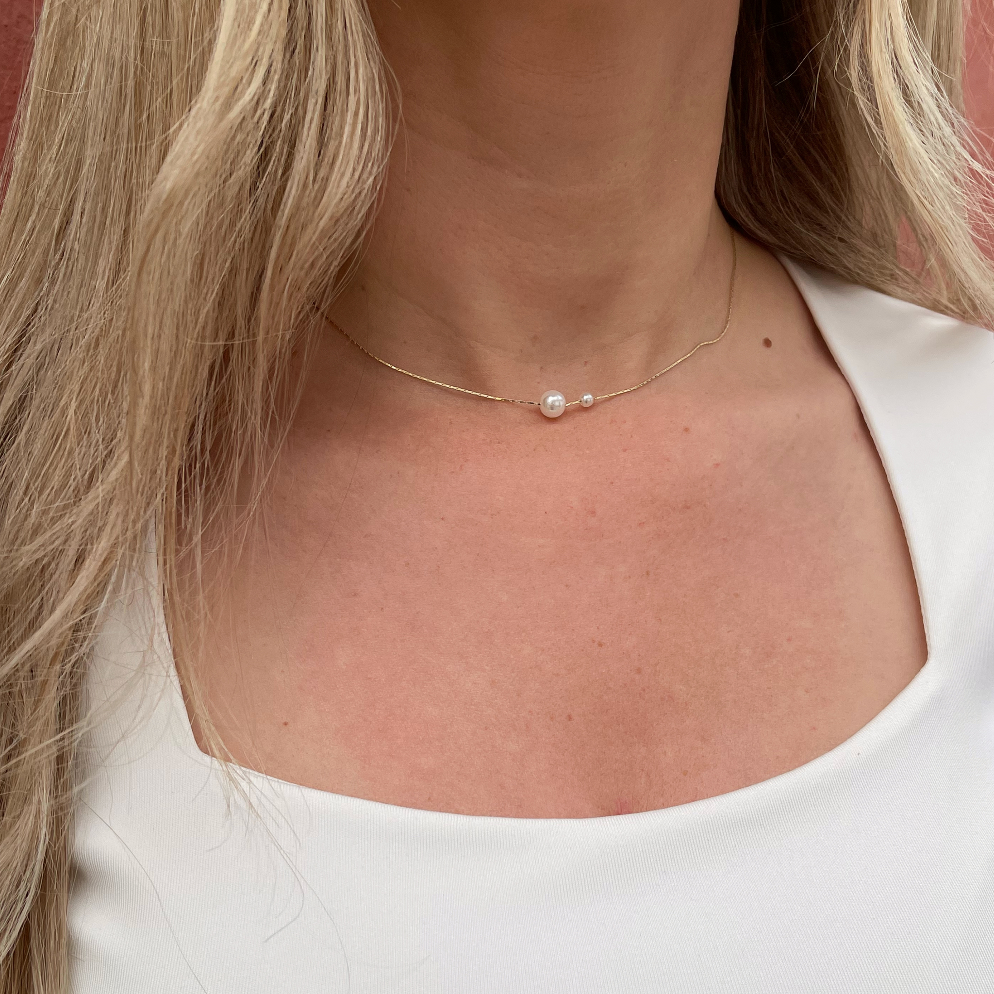 Guld Ella halskæde med 2 flotte perler på i forskellige størrelser, som er med til at give smykket et unikt look.   Halskæden er guldbelagt med 24 karat guld.  Længde: 42 cm - kan justeres Materiale: 24 karat guldbelagt messing, perler