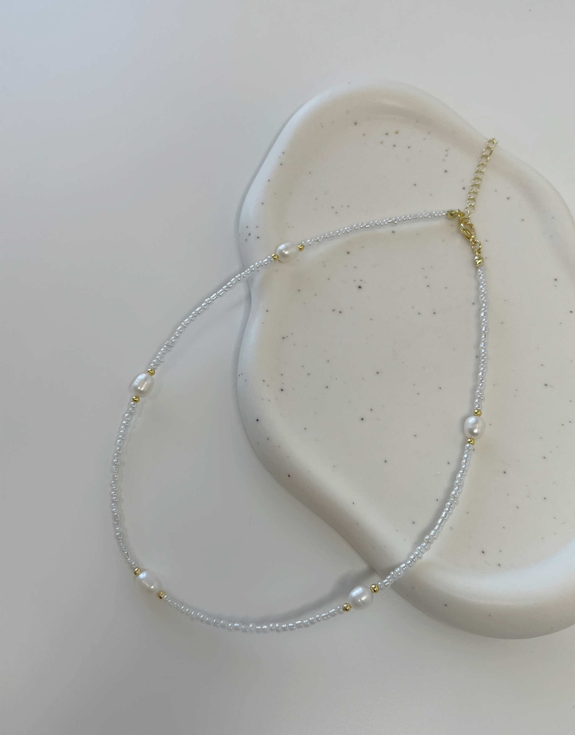 Nellie halskæde fyldt med perler.  Denne halskæde er til dig, som elsker, at pifte dit look op med unikke smykker.   Materiale: Rustfri stål, guldbelagt. Perler. 100% nikkelfri.