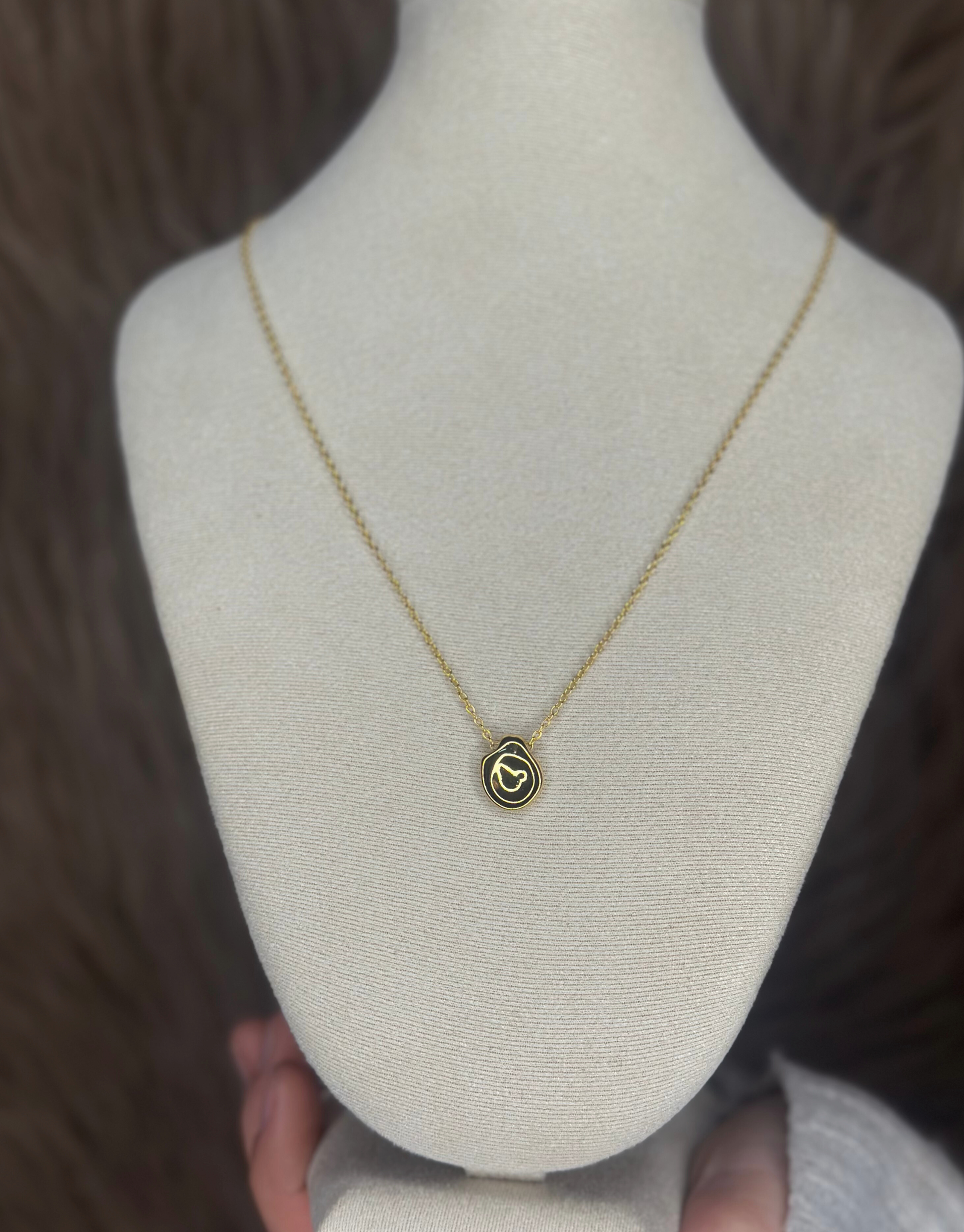 Smuk guld halskæde med abstrakt vedhæng.