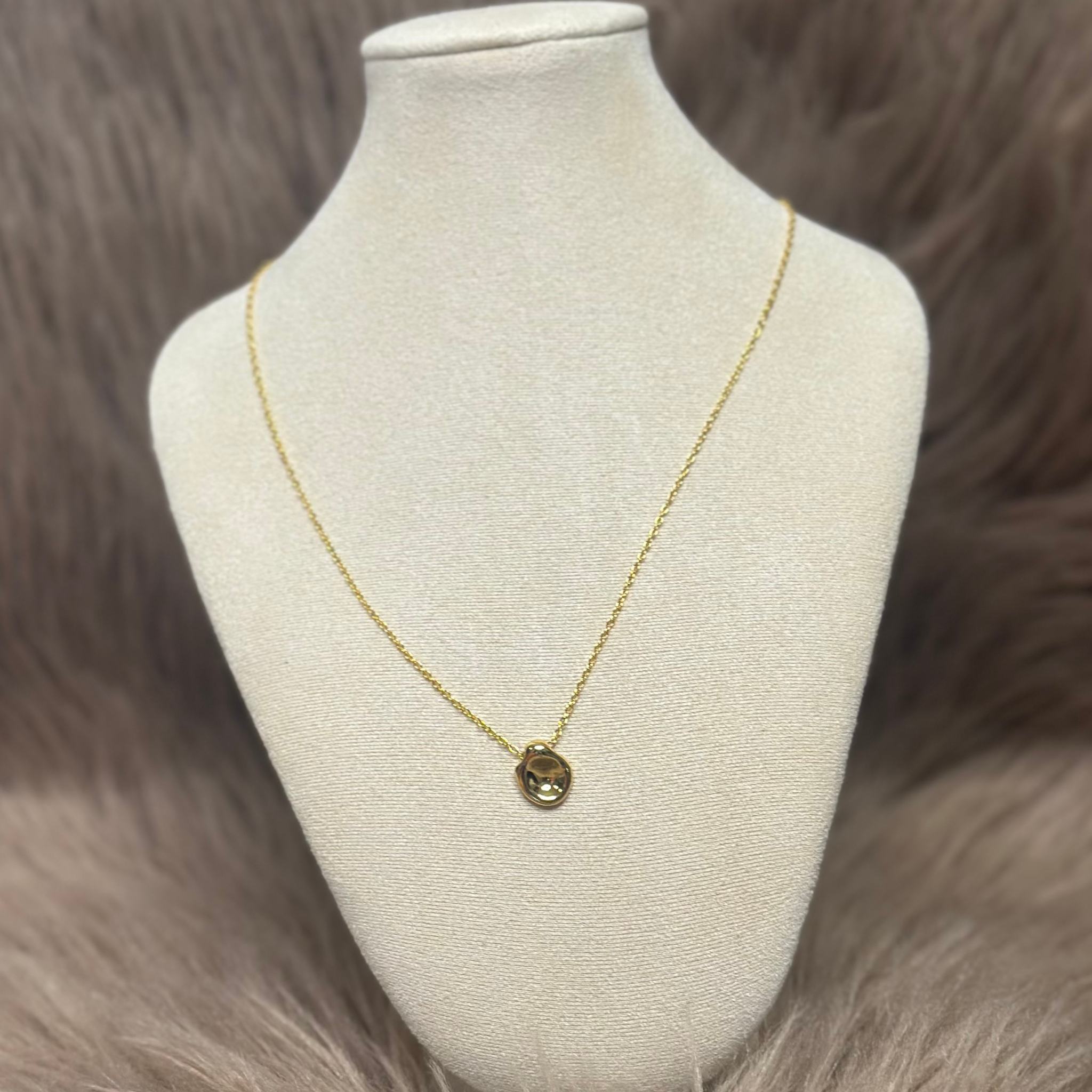 Smuk guld halskæde med abstrakt vedhæng.