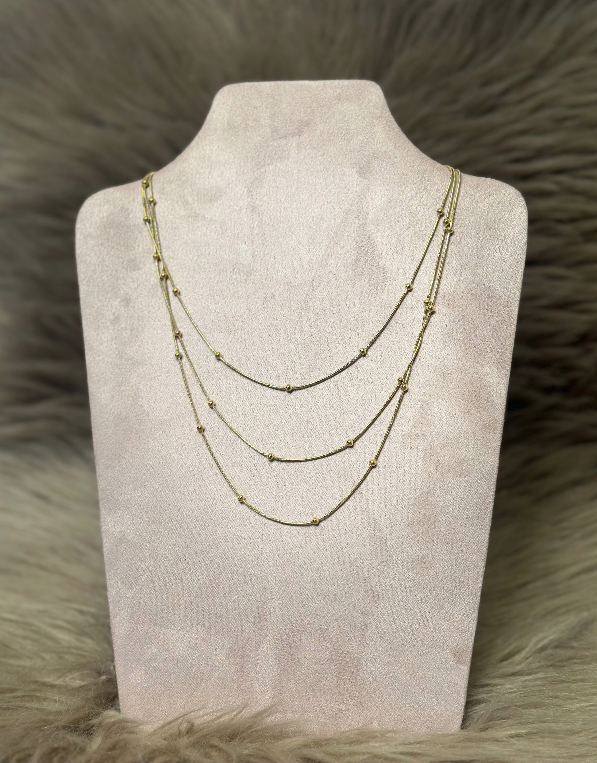 Smuk halskæde i guld med tre kæder med flotte detaljer.