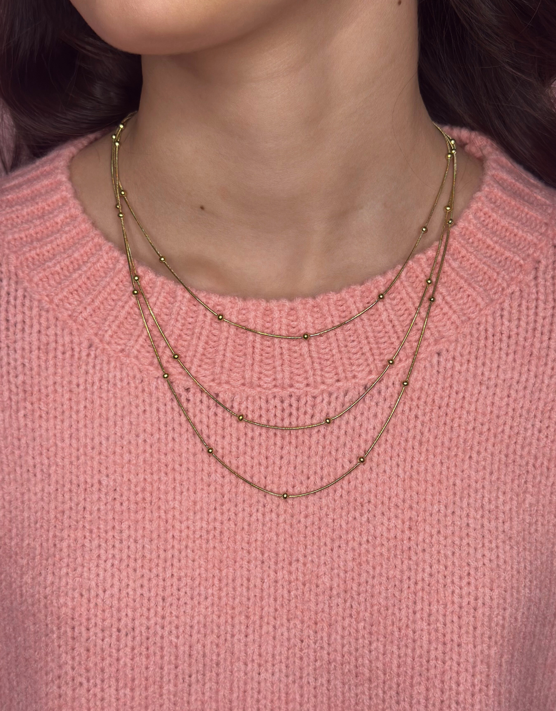 Smuk halskæde i guld med tre kæder med flotte detaljer.