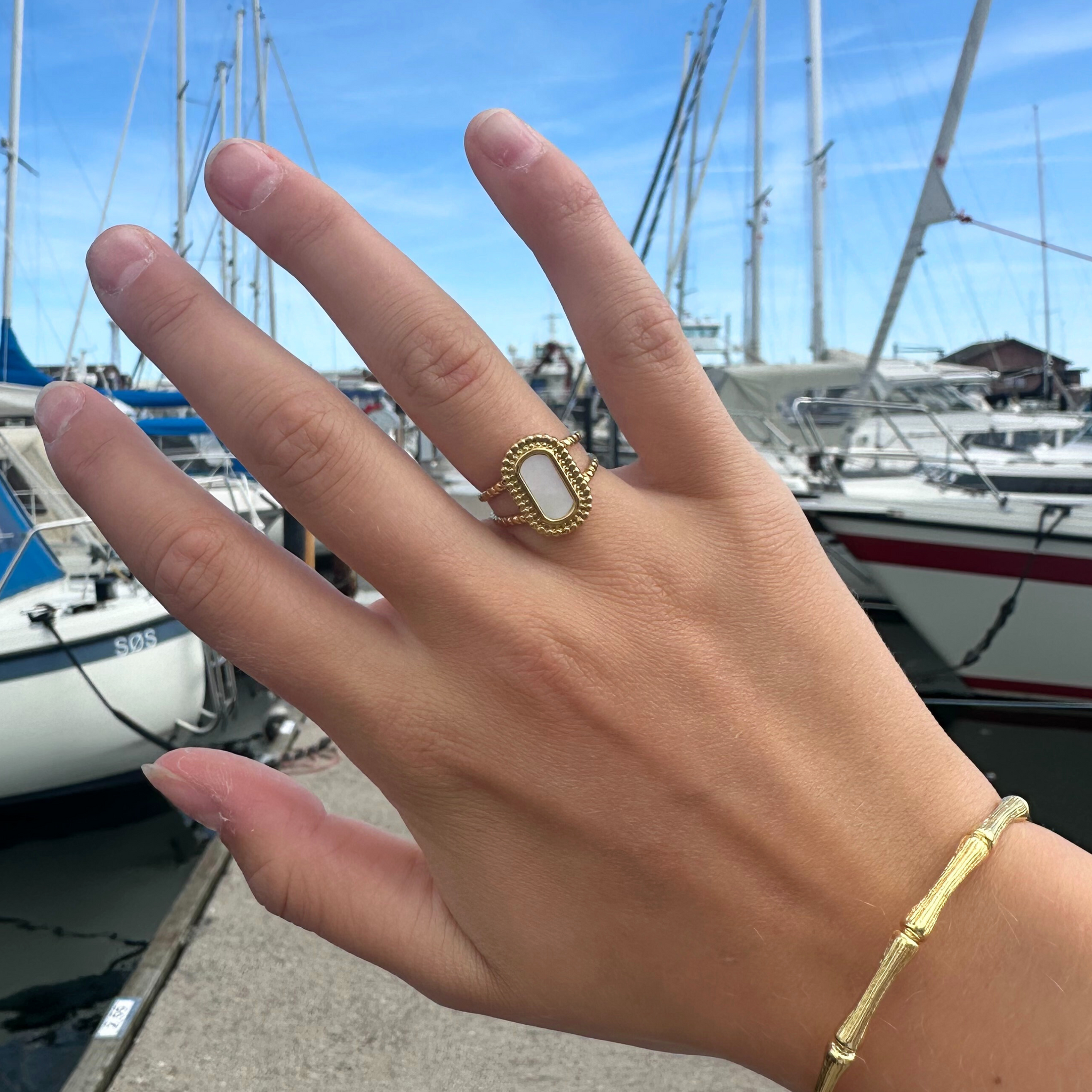 Smuk ring i guld med flot lys sten med perlemor-effekt.