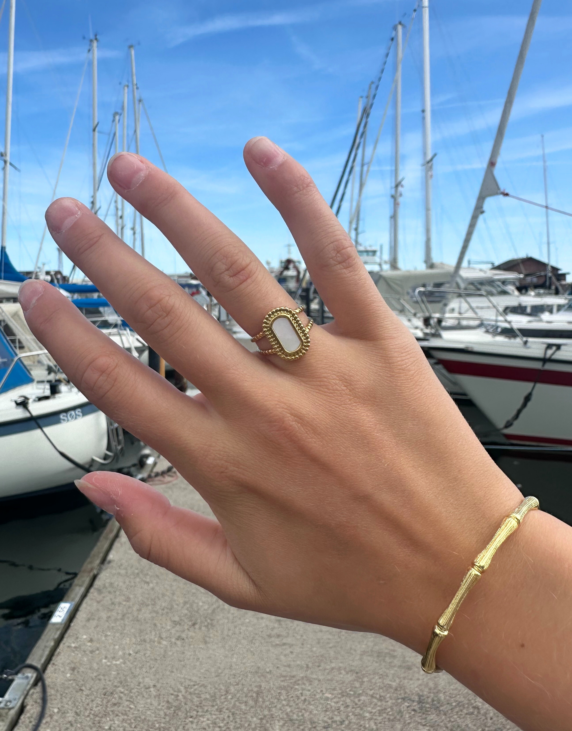 Smuk ring i guld med flot lys sten med perlemor-effekt.