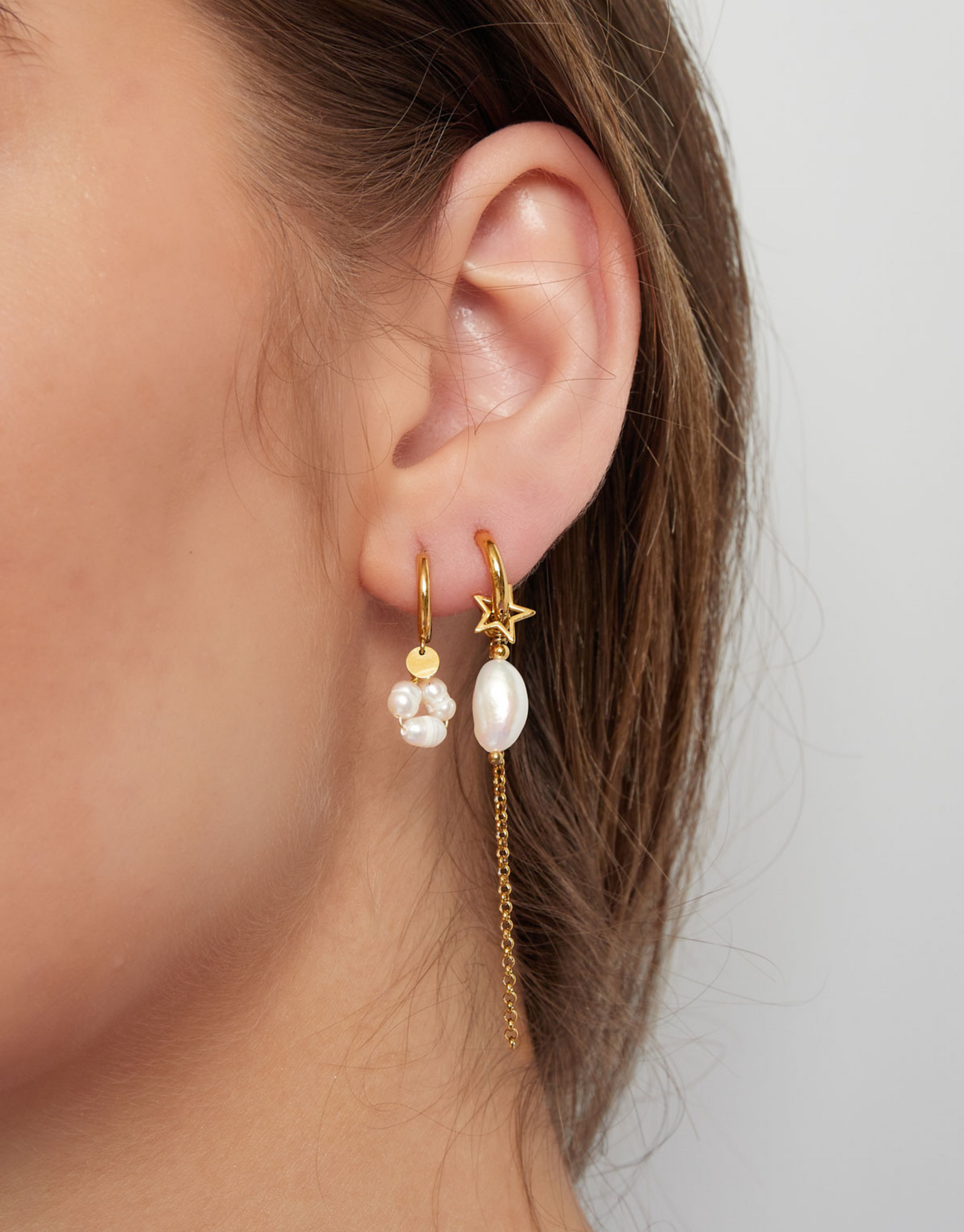 Unikke øreringe med det smukkeste vedhæng af ferskvandsperle og stjerne vedhæng.  Disse øreringe er til dig, der virkelig elsker, at spice dit look op med unikke smykker.  Materiale: Rustfri stål, 14 karat guldbelægning. 100% nikkelfri Størrelse: 1.2 x 6.3 cm