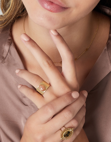 Smuk ring med stor lyserød sten.  Denne ring er til dig, der virkelig elsker, at spice dit look op med unikke smykker. Materiale: Overfladebehandlet rustfri stål, 14 karat guldbelægning. Lyserød sten. 100% nikkelfri.