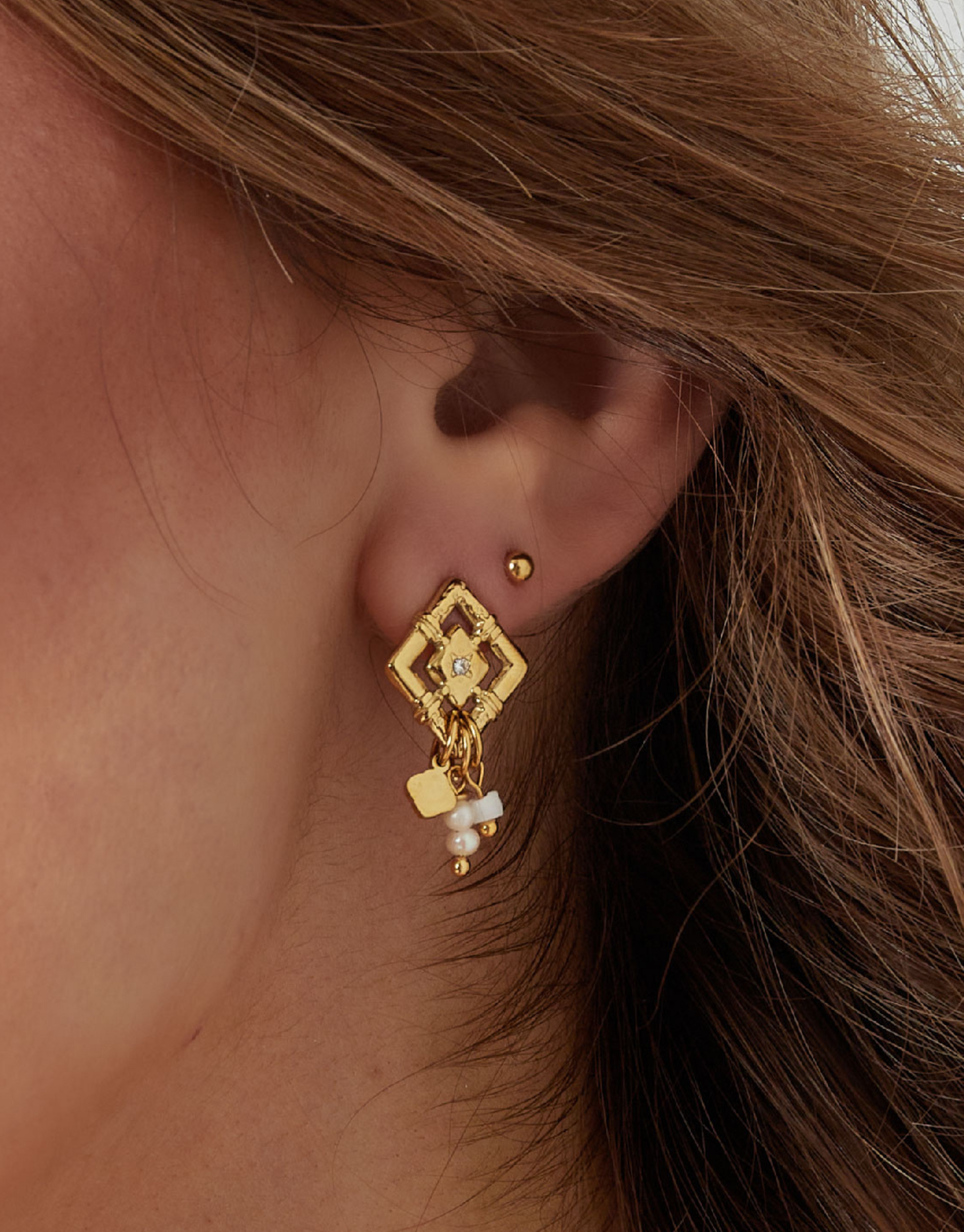 Vores Adaya øreringe er elegante og med det flotteste perle vedhæng.   Disse øreringe er til dig, der elsker, at spice dit look up med unikke smykker.   Materiale: Overfladebehandlet rustfri stål, perler, forgyldt med 14 karat. 100% Nikkelfri. Størrelse: 2.6 cm + 1,4 cm