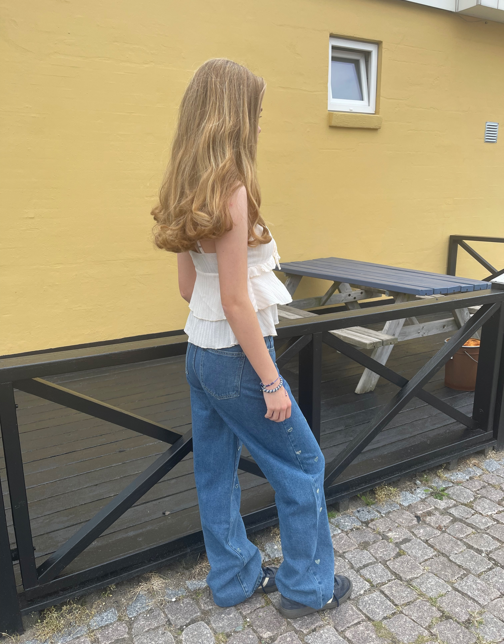 Smuk top med v-udskæring, blondedetaljer og sløjfe ved brystet.