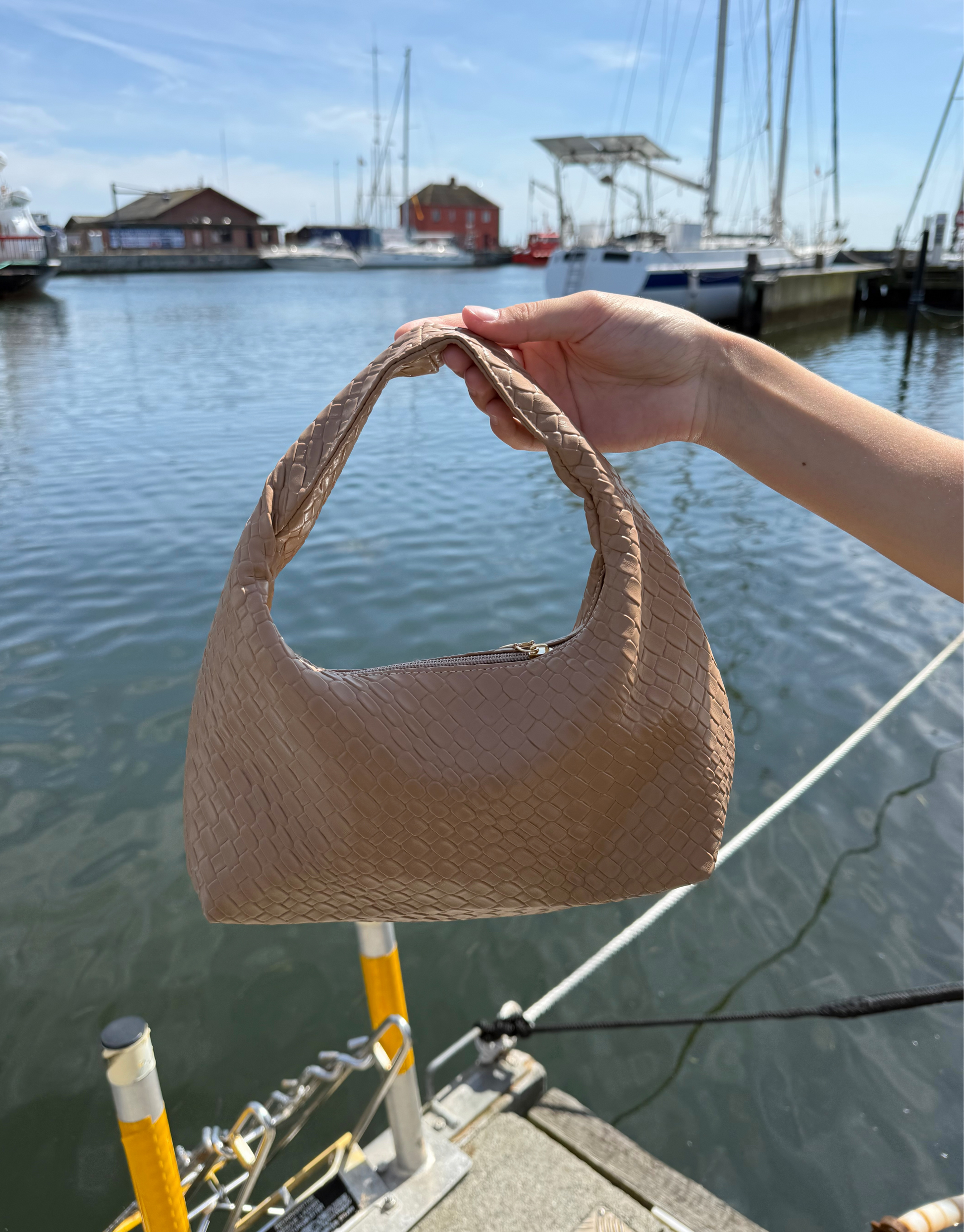 Den populære taske i flet med lynlås.