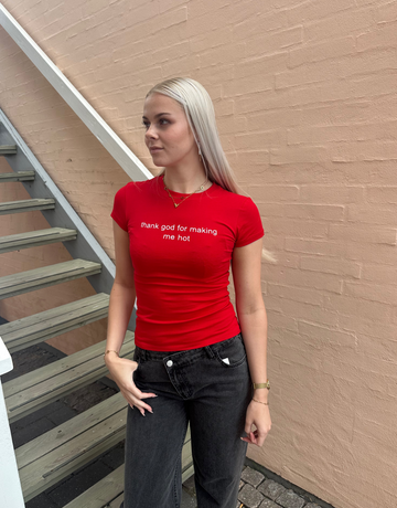Rød t-shirt med teksten ''Thank god for making me hot''.