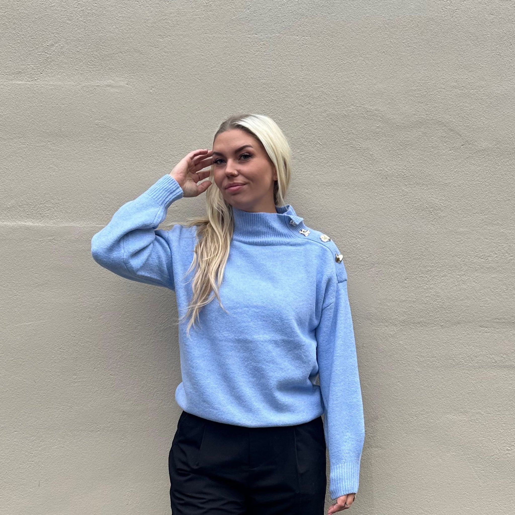 Lækker varm strik i den flotteste lyseblå farve med guld detaljer ved halsen.