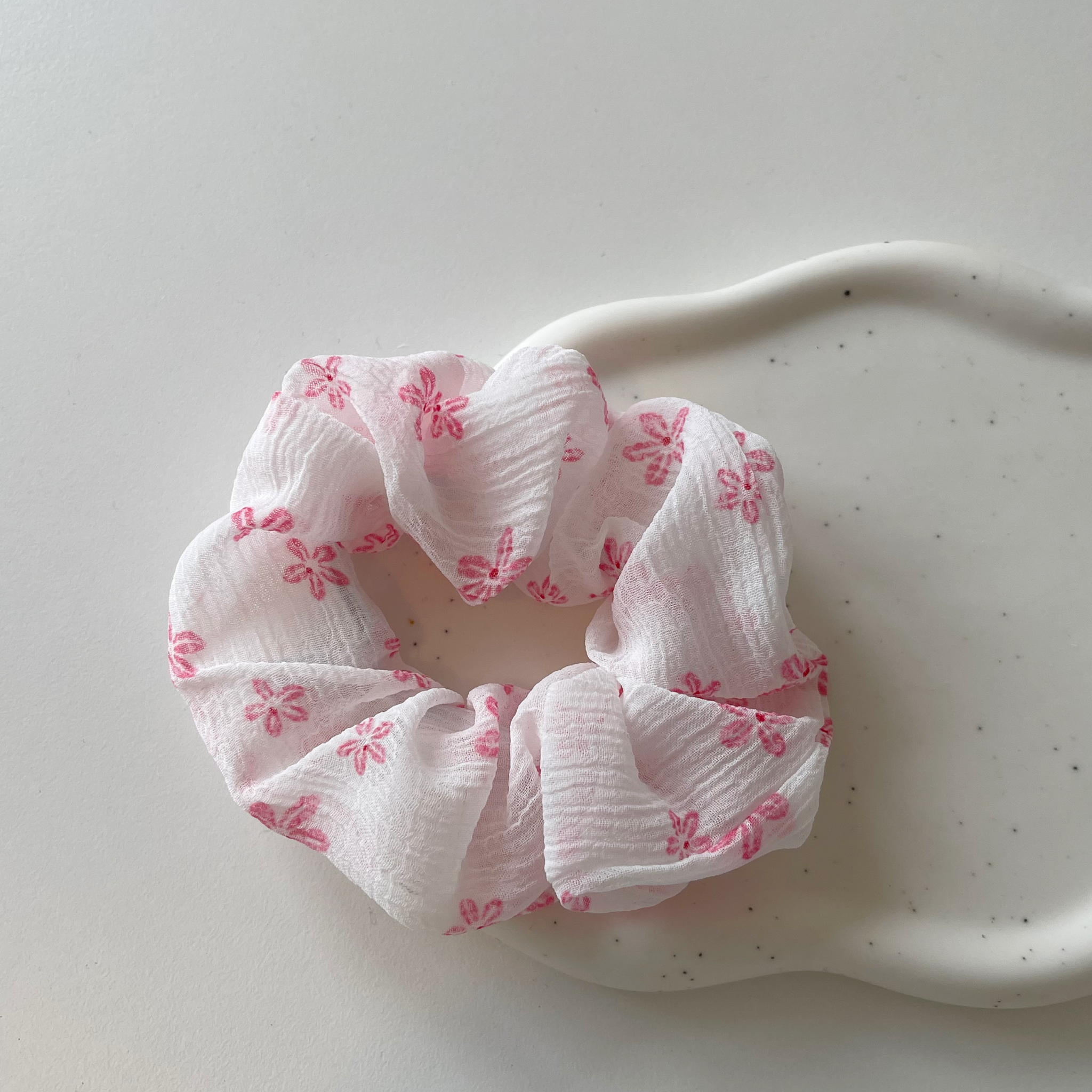 Sød scrunchie i hvid med lyserøde blomster.  Disse scrunchie er nemme at style med - og giver virkelig et sødt pift til håret.