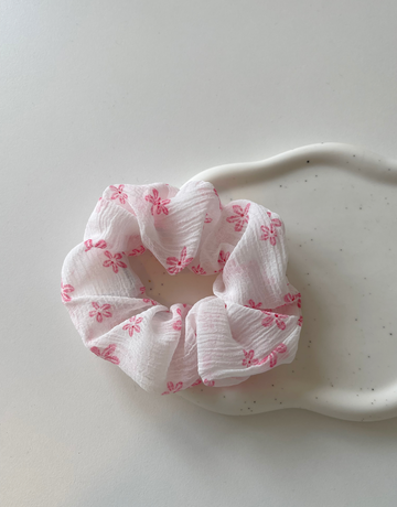 Sød scrunchie i hvid med lyserøde blomster.  Disse scrunchie er nemme at style med - og giver virkelig et sødt pift til håret.