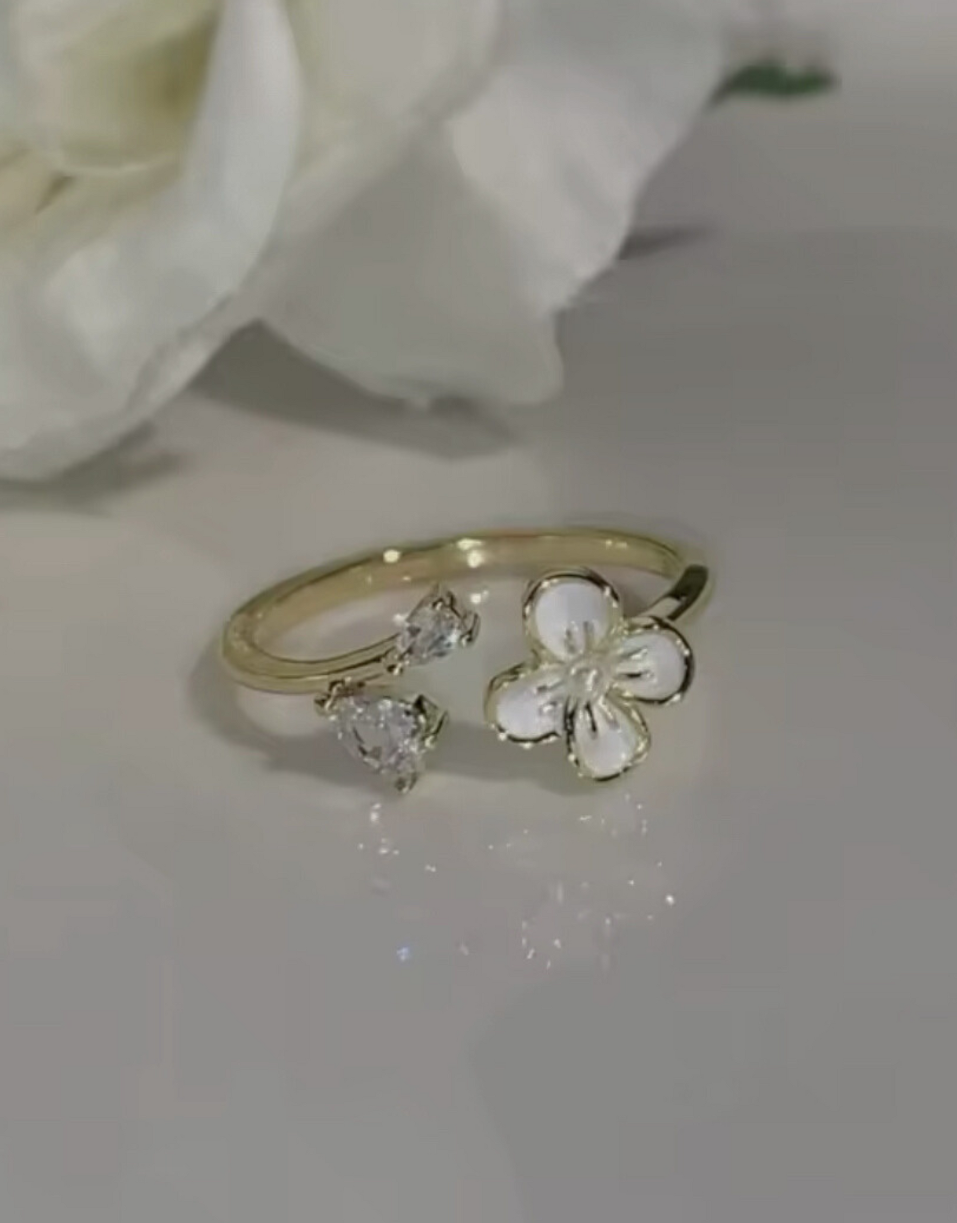 Smuk og elegant ring i guld med blomster motiv og zircon sten.