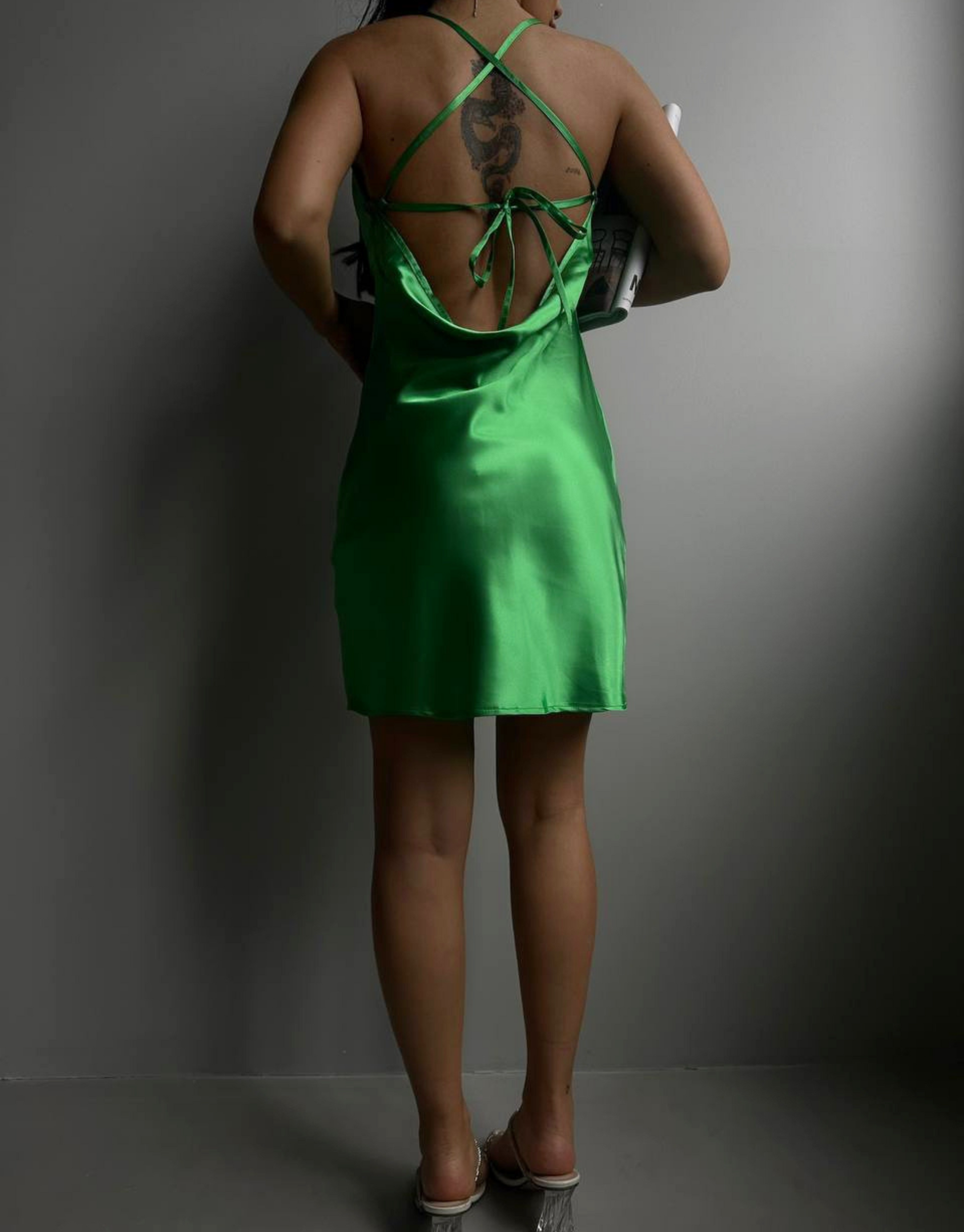 Carrie kjole i grøn.  Skøn grøn kjole i satin-look med stropper og unik binding på ryggen.  Materiale: 100% polyester Modellens størrelse: Modellen er 167 cm høj og har en størrelse S på. Normal i størrelsen.