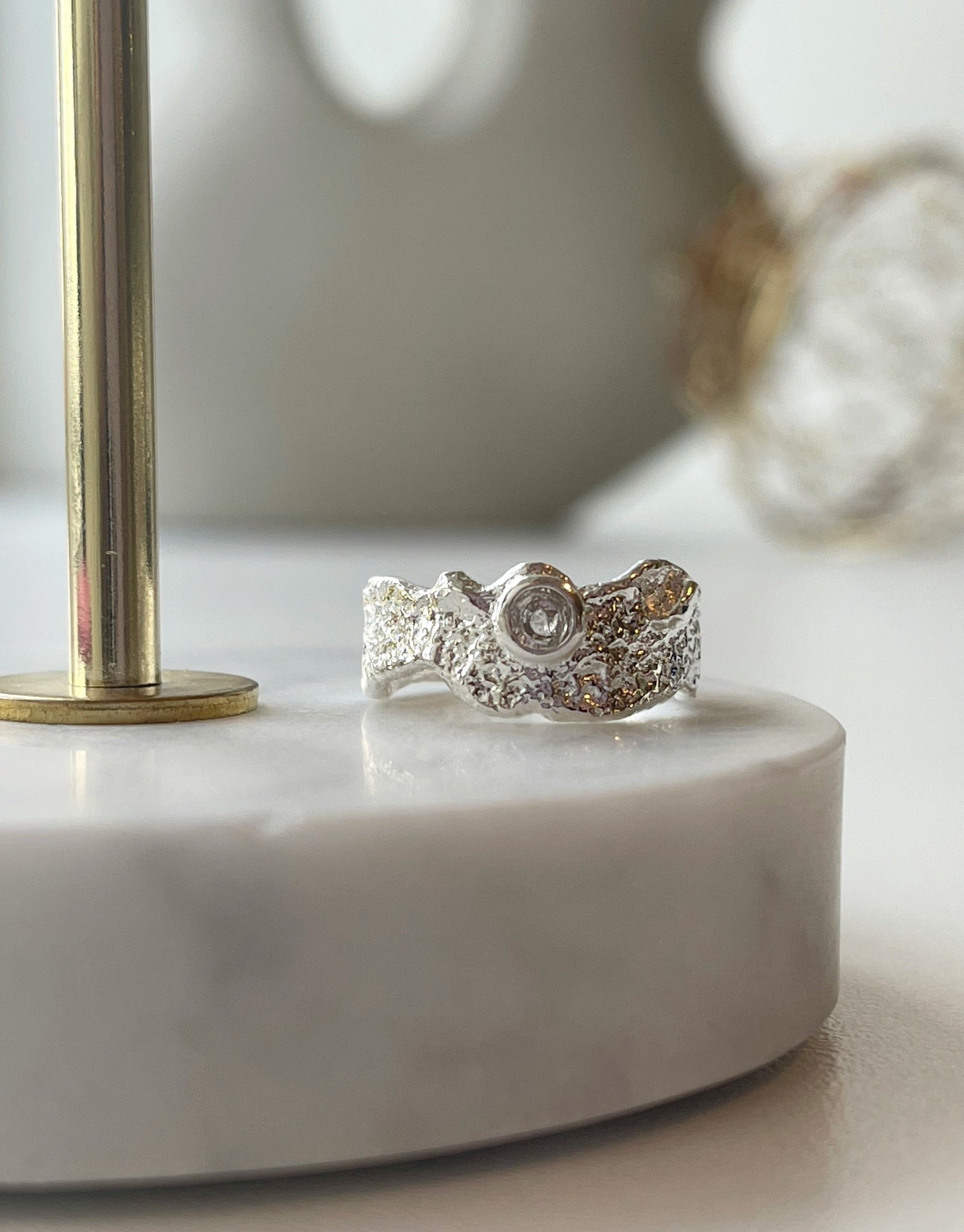 Lilje ring i sølv.  Elegant ring i guld med de fineste detaljer og en lille zircon sten i. Ringen er i et mat guld look med abstrakte deltaljer.