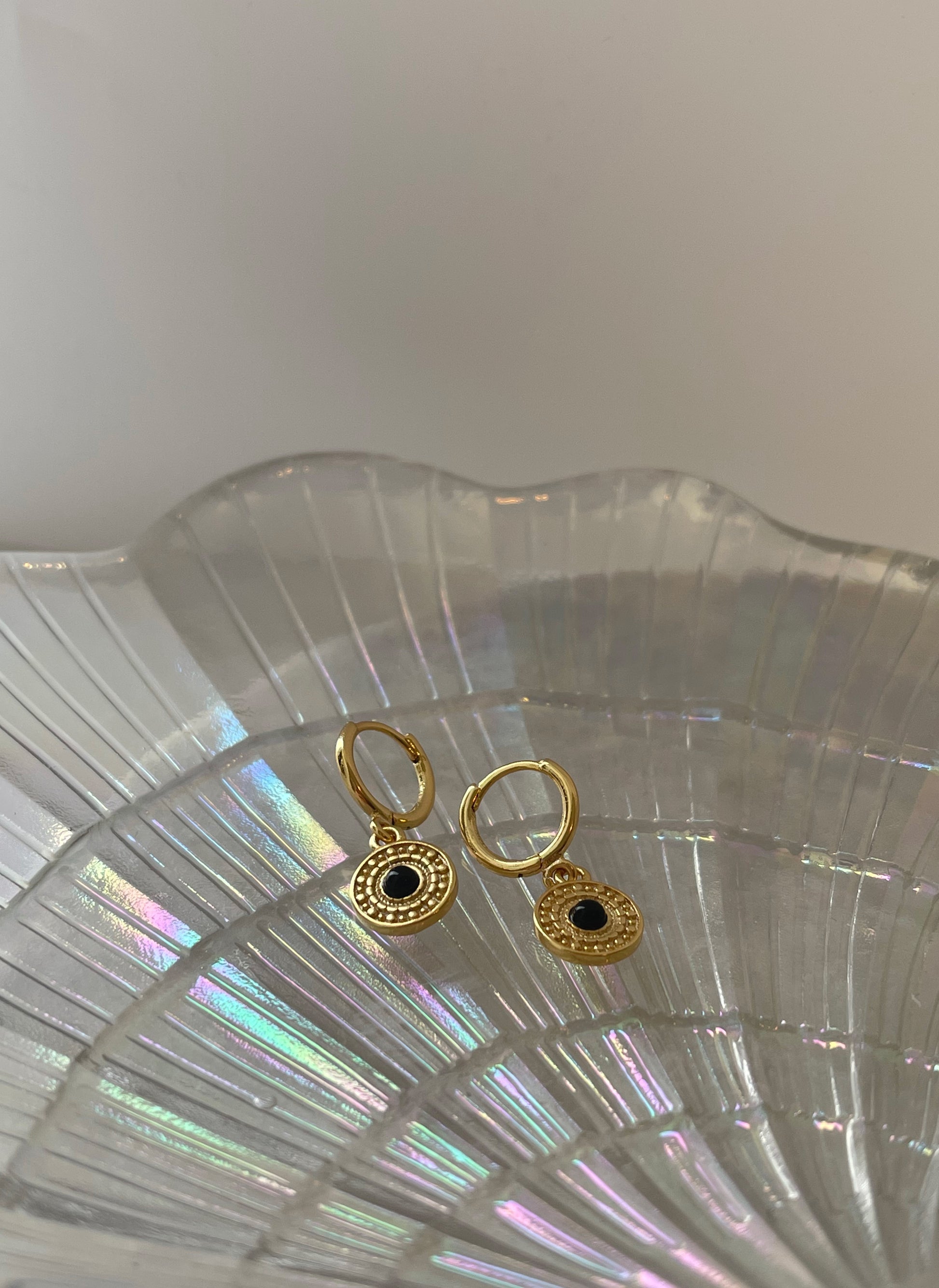 Alkina øreringe i guld med mønster og flot sort sten.   Disse øreringe er til dig, som elsker, at spice dit look op med unikke smykker.  Øreringe kan bæres alene, men kan også mixes med vores mange andre øreringe. Materiale: S925 sterling sølv, 14 karat guldbelagt, kliklås, nikkelfri