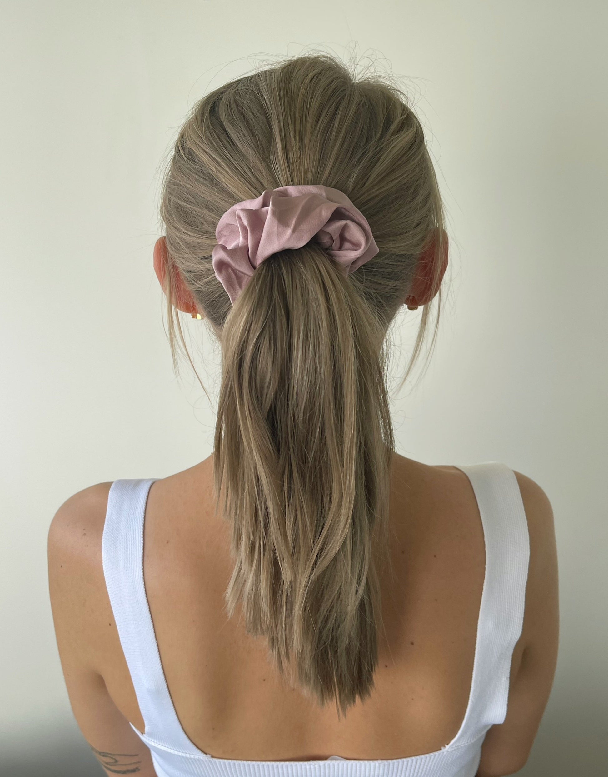 Rosa scrunchie i satin  Disse scrunchies er mellem størrelse.  Der rigtig gode til at holde på håret og nemme at style med. De er elastiske og har stofbetræk, og kan fås i flere forskellige farver.