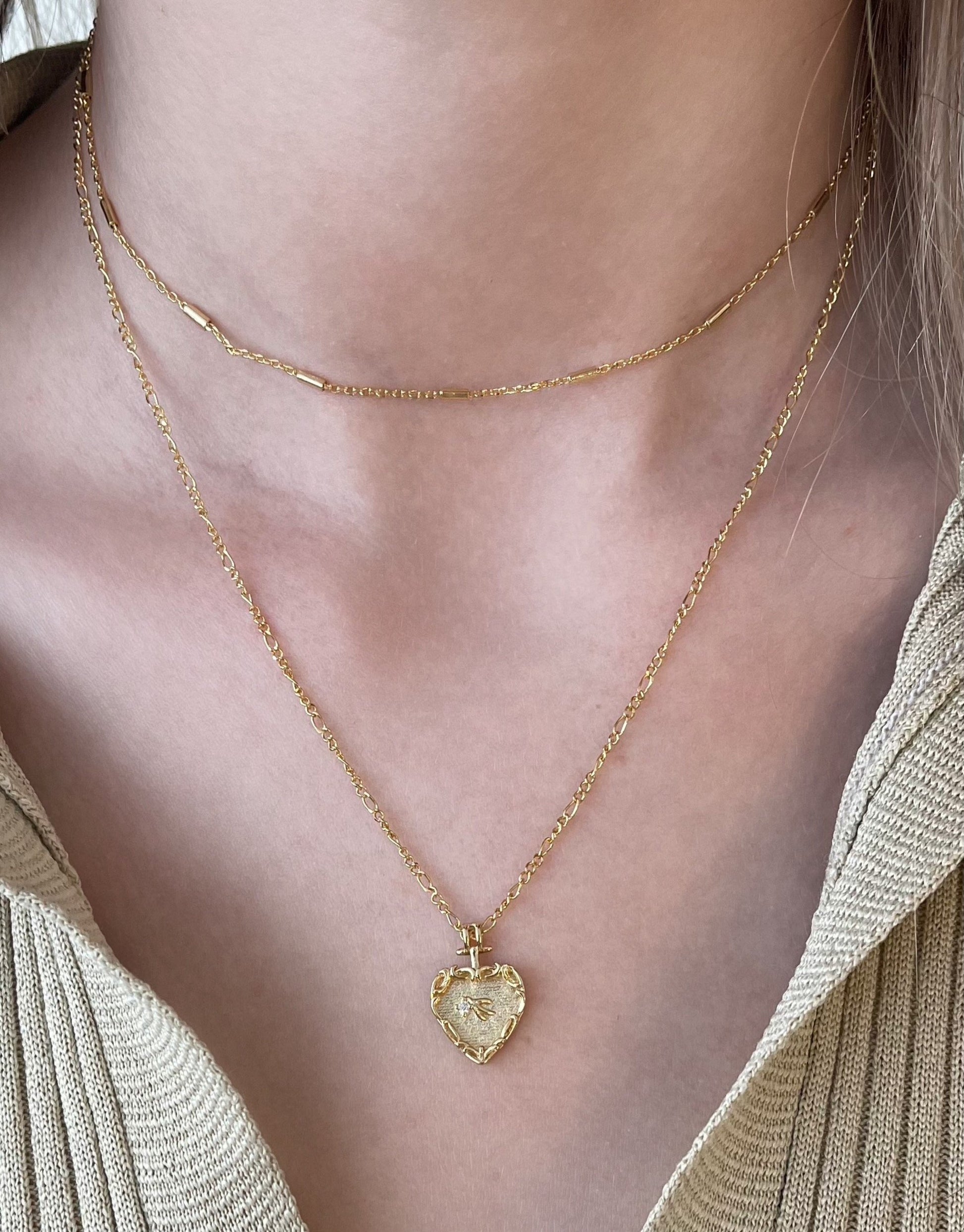 Lara halskæde i guld med dobbelt kæde samt det flotteste hjerteformet vedhæng med motiv i.